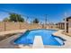 A beautiful in-ground pool with a diving board is surrounded by mature landscaping at 3562 W Seldon Ln, Phoenix, AZ 85051