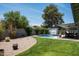 Spacious backyard featuring a well-maintained lawn, a sparkling pool, and a covered patio, ideal for outdoor enjoyment at 3759 E Charter Oak Rd, Phoenix, AZ 85032