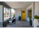 Inviting front porch with seating, potted plants, and a bright yellow door, creating a welcoming entrance at 3759 E Charter Oak Rd, Phoenix, AZ 85032