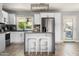 Modern kitchen featuring white cabinets, stainless steel appliances, stone countertops, and a stylish island at 3759 E Charter Oak Rd, Phoenix, AZ 85032