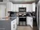 Well-appointed kitchen with white cabinets, granite countertops, stainless steel appliances and modern finishes at 3759 E Charter Oak Rd, Phoenix, AZ 85032