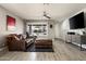 Cozy living room showcasing a comfortable leather sofa, modern ceiling fan, and stylish decor at 3759 E Charter Oak Rd, Phoenix, AZ 85032