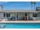 Covered patio featuring outdoor dining and seating area by the sparkling pool at 3759 E Charter Oak Rd, Phoenix, AZ 85032