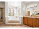 Bright bathroom featuring a soaking tub with shuttered windows and marble countertops at 41503 N 109Th Pl, Scottsdale, AZ 85262