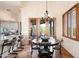 Open concept dining room features a modern chandelier, glass doors to outdoor living space, and bar stool seating to kitchen at 41503 N 109Th Pl, Scottsdale, AZ 85262
