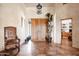 This foyer features double wooden doors, tile floor, an ornate light fixture and flows seamlessly into other living spaces at 41503 N 109Th Pl, Scottsdale, AZ 85262