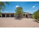 Charming home featuring a large driveway, mature tree, and three car garage under a beautiful blue sky at 41503 N 109Th Pl, Scottsdale, AZ 85262