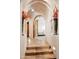 Arched hallway with tiled floors, recessed lighting, and flower vases leading into a bright bedroom with natural light at 41503 N 109Th Pl, Scottsdale, AZ 85262