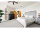 Large main bedroom features a ceiling fan, dark wood dresser, gray bed frame, arched doorways, and neutral decor at 41503 N 109Th Pl, Scottsdale, AZ 85262