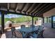 Covered patio with dining table, chairs, and an outdoor oven, surrounded by desert landscape at 41503 N 109Th Pl, Scottsdale, AZ 85262