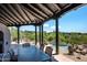 Covered patio with dining table, chairs, and views of the pool and desert landscape at 41503 N 109Th Pl, Scottsdale, AZ 85262