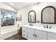 Bright bathroom featuring a double sink vanity, modern mirrors, and natural light at 4515 E Verbena Dr, Phoenix, AZ 85044
