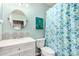 Bright bathroom showcases a vanity with decorative tile, unique shower curtain, and round mirror at 4515 E Verbena Dr, Phoenix, AZ 85044