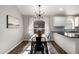 Dining room with a modern chandelier, white cabinets and dark countertops at 4515 E Verbena Dr, Phoenix, AZ 85044
