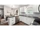 Kitchen features white cabinets, black countertops, stainless steel appliances, island with breakfast bar, and wood floors at 4515 E Verbena Dr, Phoenix, AZ 85044