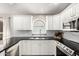 Well-lit kitchen features white cabinets, black countertops, stainless steel appliances, and subway tile backsplash at 4515 E Verbena Dr, Phoenix, AZ 85044