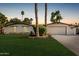 Charming single-story home featuring a lush front lawn, mature palm trees, and a two-car garage at 5333 E Sheena Dr, Scottsdale, AZ 85254