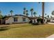 Charming single-story home featuring a well-manicured lawn, desert landscaping, and numerous stately palm trees at 5333 E Sheena Dr, Scottsdale, AZ 85254