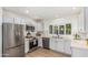 Updated kitchen with stainless steel appliances, white cabinets, tile backsplash, and modern fixtures at 5333 E Sheena Dr, Scottsdale, AZ 85254
