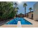 Sparkling swimming pool surrounded by lush landscaping and palm trees at 5333 E Sheena Dr, Scottsdale, AZ 85254