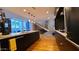 Open-concept kitchen with black cabinetry, stainless appliances, stone countertops, and wood floors at 5455 E Lincoln Dr # 1004, Paradise Valley, AZ 85253