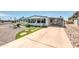 Home exterior showcasing a lush landscaped yard with stepping stones, gravel, turf, plants and a covered parking area at 632 S 83Rd Way, Mesa, AZ 85208