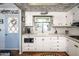 Well-lit kitchen with white cabinetry, stainless steel appliances, and hardwood floors at 632 S 83Rd Way, Mesa, AZ 85208