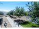 Landscaped yard with an arrangement of flowering trees, decorative gravel, artificial turf and a gray paver walkway at 632 S 83Rd Way, Mesa, AZ 85208
