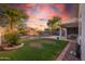 Home backyard with a pool, patio, green grass and desert landscaping all around at 7463 E Monte Ave, Mesa, AZ 85209