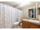 Well-lit bathroom featuring a vanity with granite countertop, a mirror, and a shower with a colorful curtain at 7463 E Monte Ave, Mesa, AZ 85209