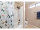 Bright bathroom with shower and tub combo, toilet and large window for natural light at 7463 E Monte Ave, Mesa, AZ 85209