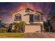 Charming two-story home with desert landscaping, an attached two-car garage, and a colorful sunset sky at 7463 E Monte Ave, Mesa, AZ 85209