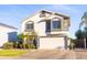 Charming two-story home with a spacious garage and palm trees in front at 7463 E Monte Ave, Mesa, AZ 85209