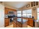 A well-lit kitchen features wooden cabinets, stainless steel appliances, and a granite countertop island at 7463 E Monte Ave, Mesa, AZ 85209