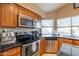 This kitchen offers stainless steel appliances, granite countertops, and ample lighting for meal preparation at 7463 E Monte Ave, Mesa, AZ 85209