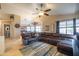 An open-concept living room featuring tile flooring, a ceiling fan, and a large leather sectional sofa at 7463 E Monte Ave, Mesa, AZ 85209