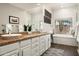 Well-lit bathroom with dual sinks, a bathtub, and a separate shower at 8601 E De La O Rd, Scottsdale, AZ 85255