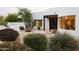 Charming Santa Fe home featuring a large picture window, custom wood accents, and professionally landscaped yard at 8601 E De La O Rd, Scottsdale, AZ 85255