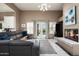 Bright living room featuring a modern fireplace, backyard access, and stylish gray sectional sofa at 8601 E De La O Rd, Scottsdale, AZ 85255