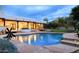 Beautiful pool at dusk featuring stone accents, water feature, landscape lighting, and patio at 8601 E De La O Rd, Scottsdale, AZ 85255