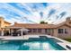 Inviting backyard features a sparkling pool with attached hot tub and outdoor kitchen with lounge areas at 8875 S Ash Ave, Tempe, AZ 85284
