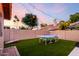 Backyard offers green artificial turf, a ping pong table, corn hole game, string lights and mature shade trees at 8875 S Ash Ave, Tempe, AZ 85284