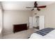 This bedroom boasts a ceiling fan, dresser, and easy access to an ensuite bathroom at 8875 S Ash Ave, Tempe, AZ 85284