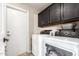 This laundry room includes black cabinets and an exterior door at 8875 S Ash Ave, Tempe, AZ 85284