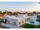An aerial view of a modern home featuring a private pool, a sleek white roof, and mountain views at 9820 N 87Th Pl, Scottsdale, AZ 85258