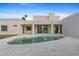 Modern backyard featuring a uniquely shaped pool, white tiled patio, and seamless indoor-outdoor living at 9820 N 87Th Pl, Scottsdale, AZ 85258