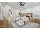 This primary bedroom features a ceiling fan, light hardwood floors, and a seating area at the foot of the bed at 9820 N 87Th Pl, Scottsdale, AZ 85258