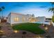 Modern home exterior with a lush green lawn, landscape lighting, and an inviting pool at 9820 N 87Th Pl, Scottsdale, AZ 85258