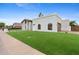 A bright, modern home featuring a well-manicured lawn and a gated garage, creating an inviting, yet private, curb appeal at 9820 N 87Th Pl, Scottsdale, AZ 85258