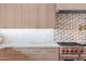 Close up of a modern kitchen with white marble countertops, backsplash and stainless steel oven at 9820 N 87Th Pl, Scottsdale, AZ 85258